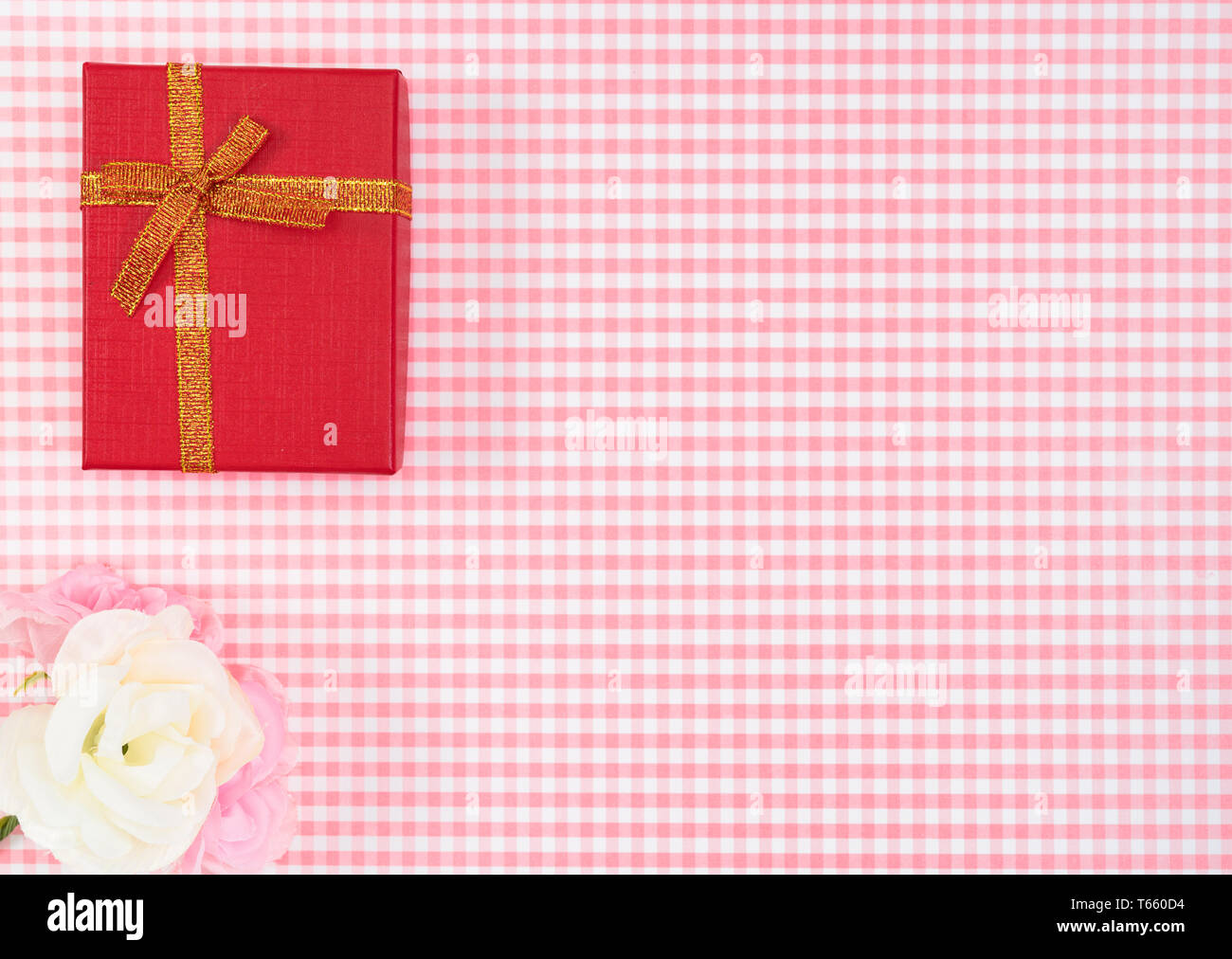 Confezione regalo con rosso isolato su sfondo scozzese. Holiday decorazione per la Festa della mamma o il giorno della donna. Foto Stock