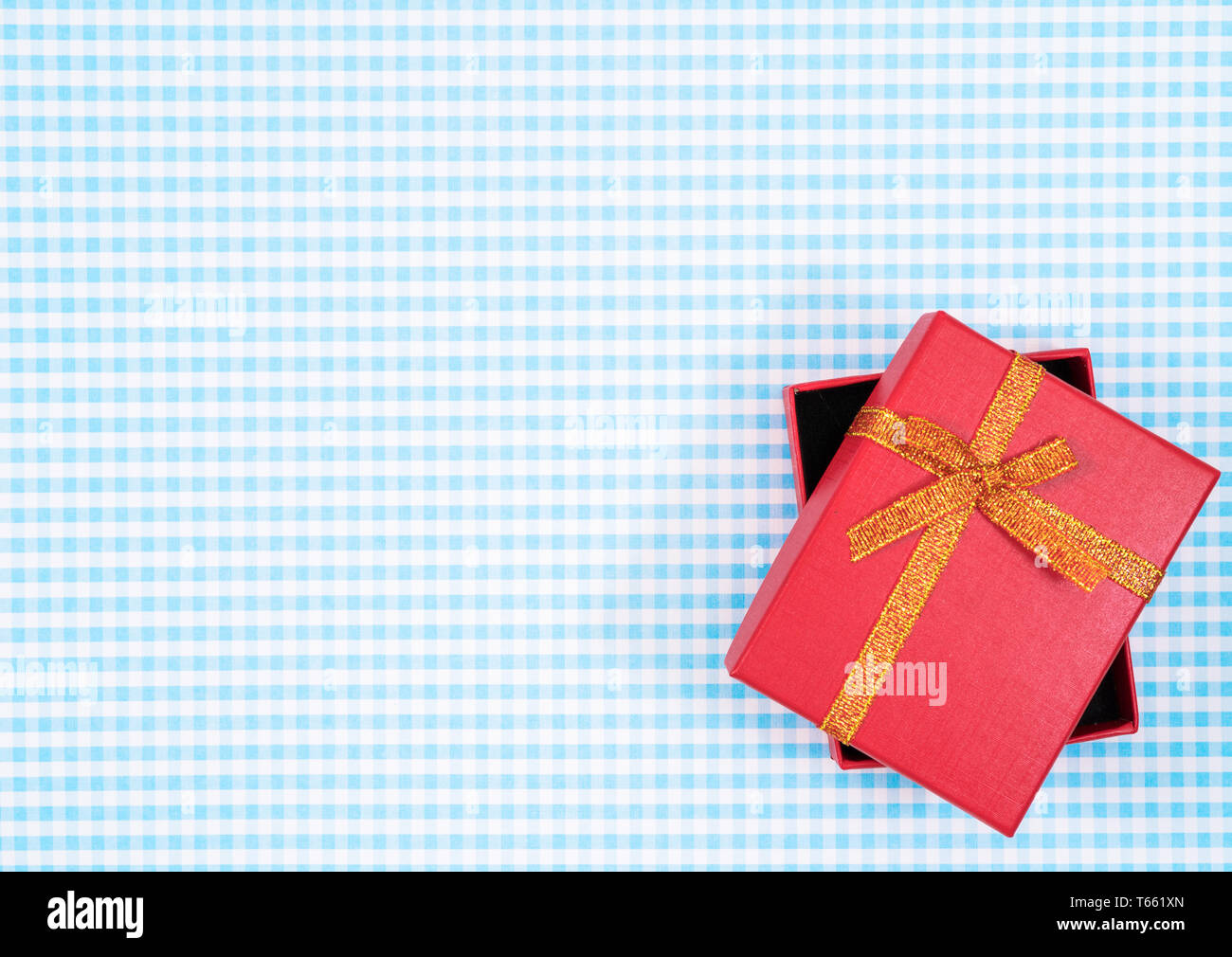 Confezione regalo con rosso isolato su sfondo scozzese. Holiday decorazione per la Festa della mamma o il giorno della donna. Foto Stock