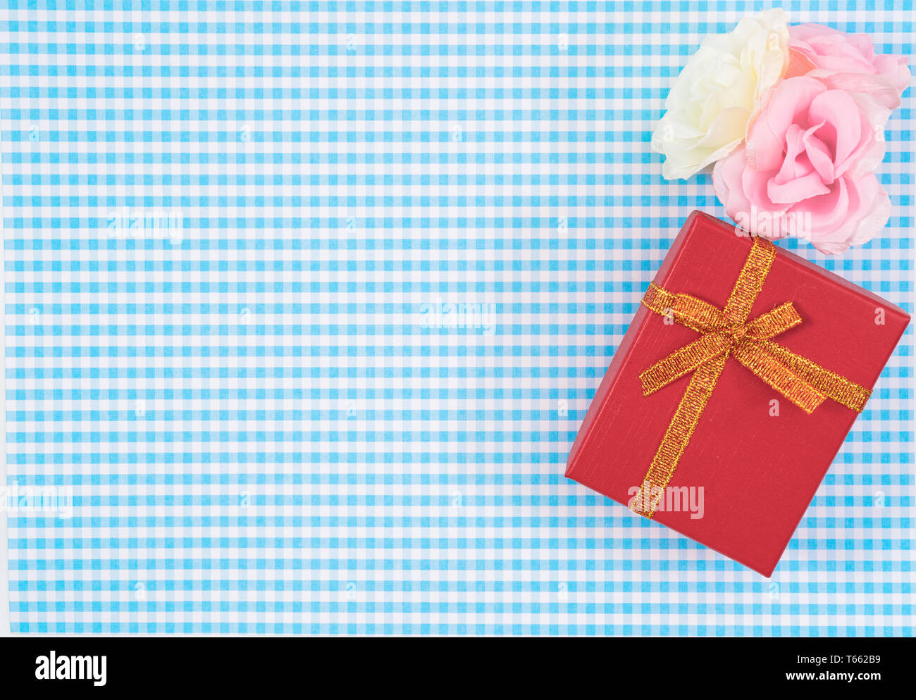 Confezione regalo con rosso isolato su sfondo scozzese. Holiday decorazione per la Festa della mamma o il giorno della donna. Foto Stock