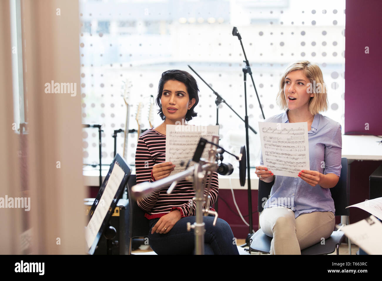 Le donne con foglio di musica a cantare in music studio di registrazione Foto Stock