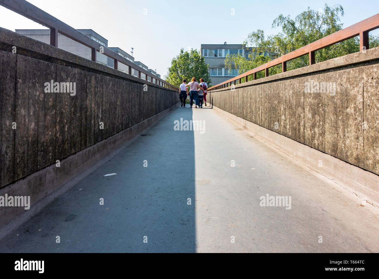 Una famiglia a piedi lungo una passerella di calcestruzzo strada ponte costruito negli anni settanta seguenti tendenze architettoniche del tempo Foto Stock