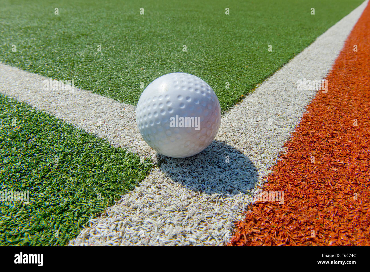 Bianco di hockey increspato sfera su astro turf Foto Stock