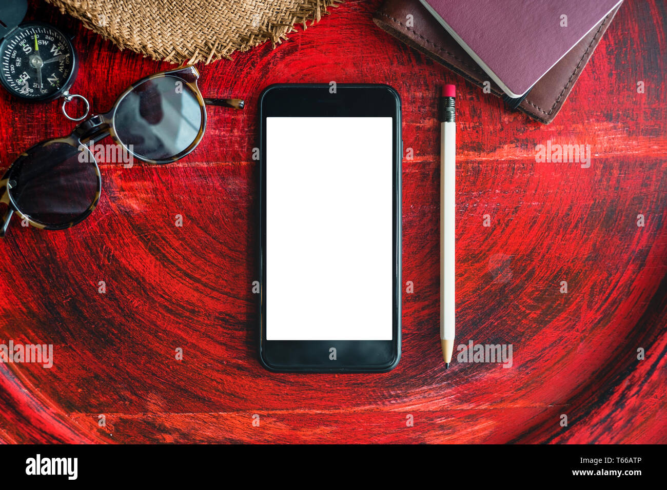 Vacanze estive ancora vita,set di mobile, passaporto ,notebook,occhiali da sole,bussola e matita bianca su rustiche in legno rosso tavola rotonda vicino alla finestra.S tropicale Foto Stock