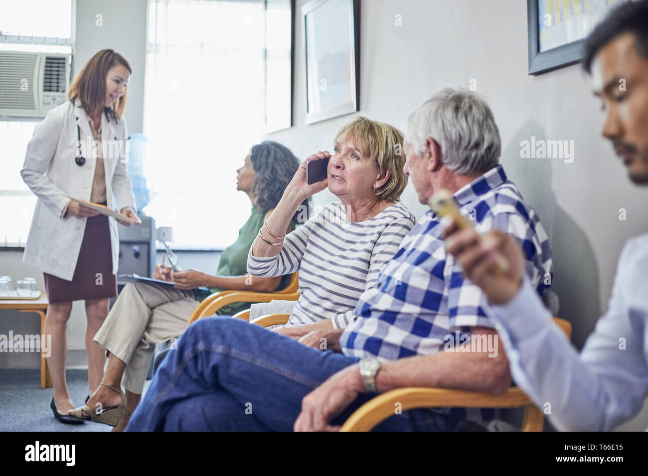 Medico e pazienti in clinica in sala d'attesa Foto Stock