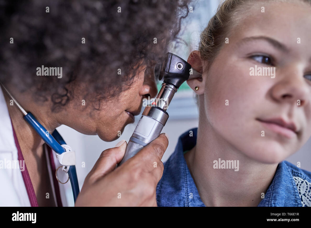 Vicino il pediatra femmina utilizzando otoscopio, esaminando l orecchio del paziente ragazza Foto Stock