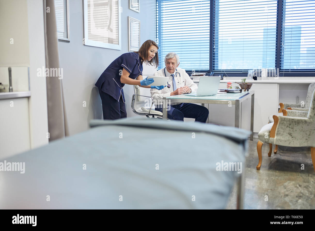 Medico e infermiere con tavoletta digitale, consulenza in clinica i medici office Foto Stock