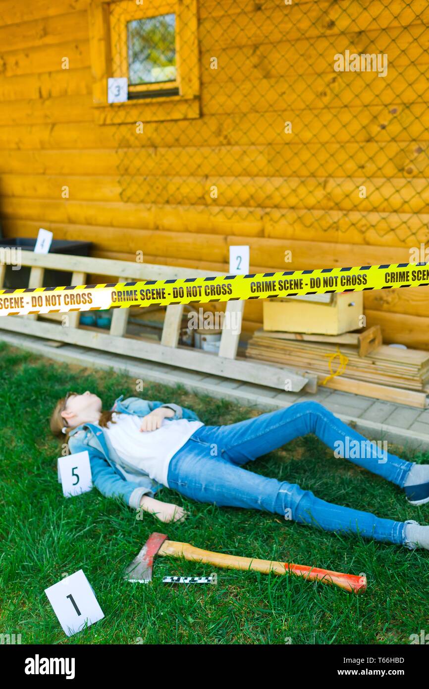 Scena del crimine nel cortile con il corpo della vittima - ax come arma - non cross Foto Stock