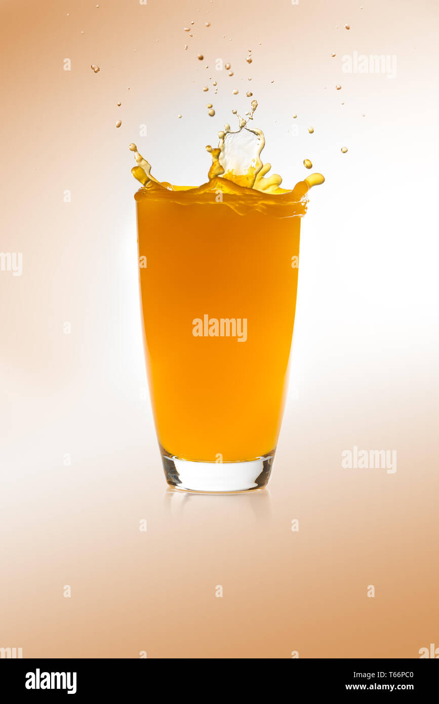 Splash su un bicchiere di succo di arancia Foto Stock