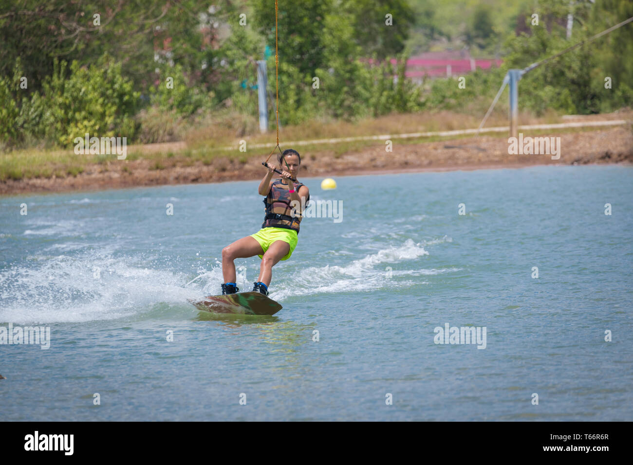 Donna studio wakeboarding su un lago blu Foto Stock