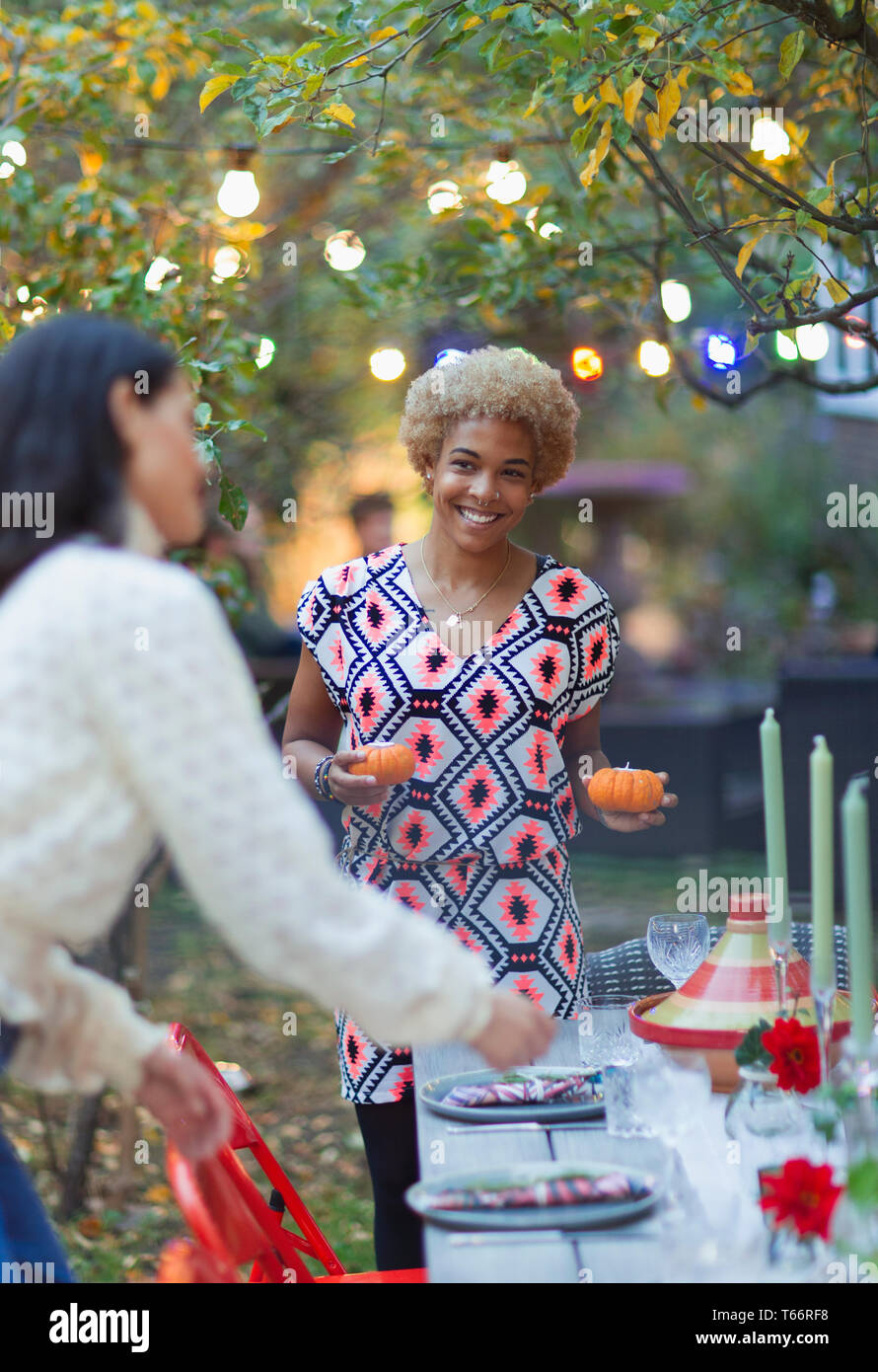 Felici donne amici nella tabella di impostazione per la cena party in giardino Foto Stock