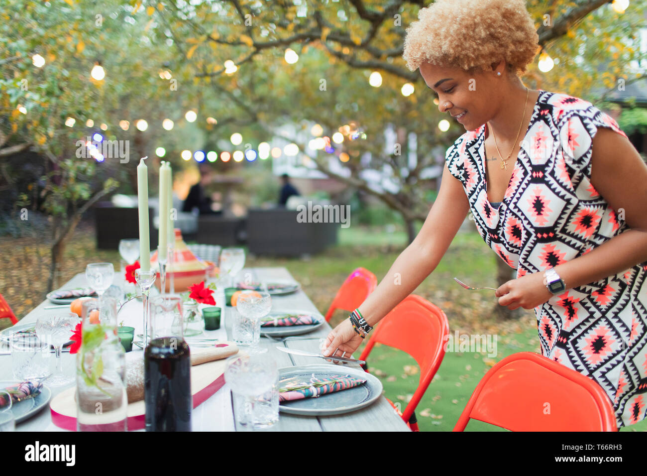 La donna nella tabella di impostazione per la cena party in giardino Foto Stock