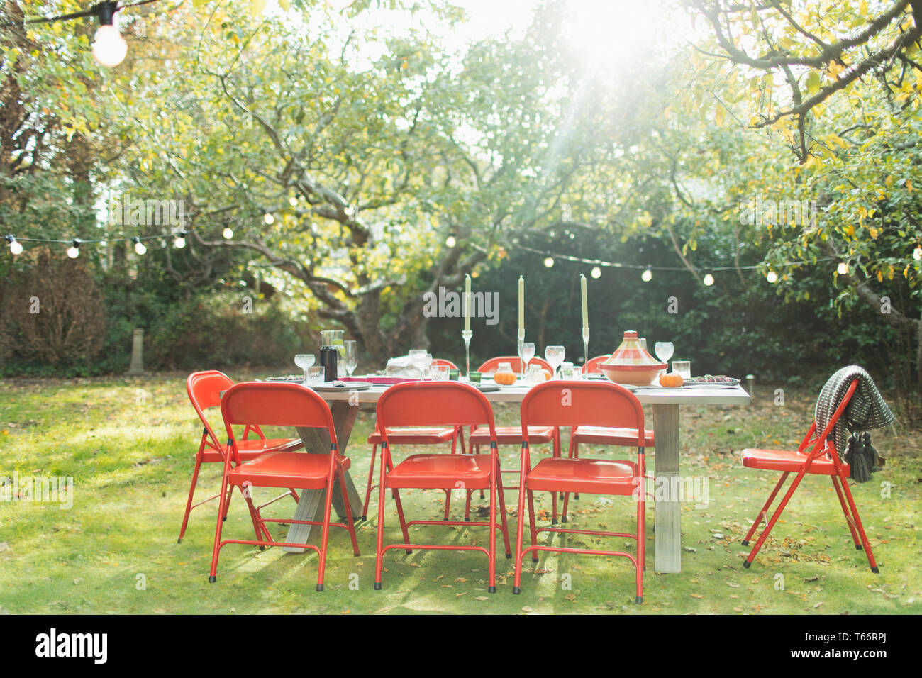 Party in giardino tavolo e luci di stringa nel cortile soleggiato Foto Stock