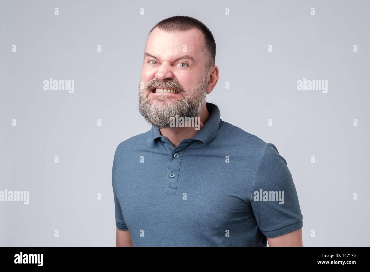 Uomo maturo arrabbiato e aggressivo bares i suoi denti. Foto Stock