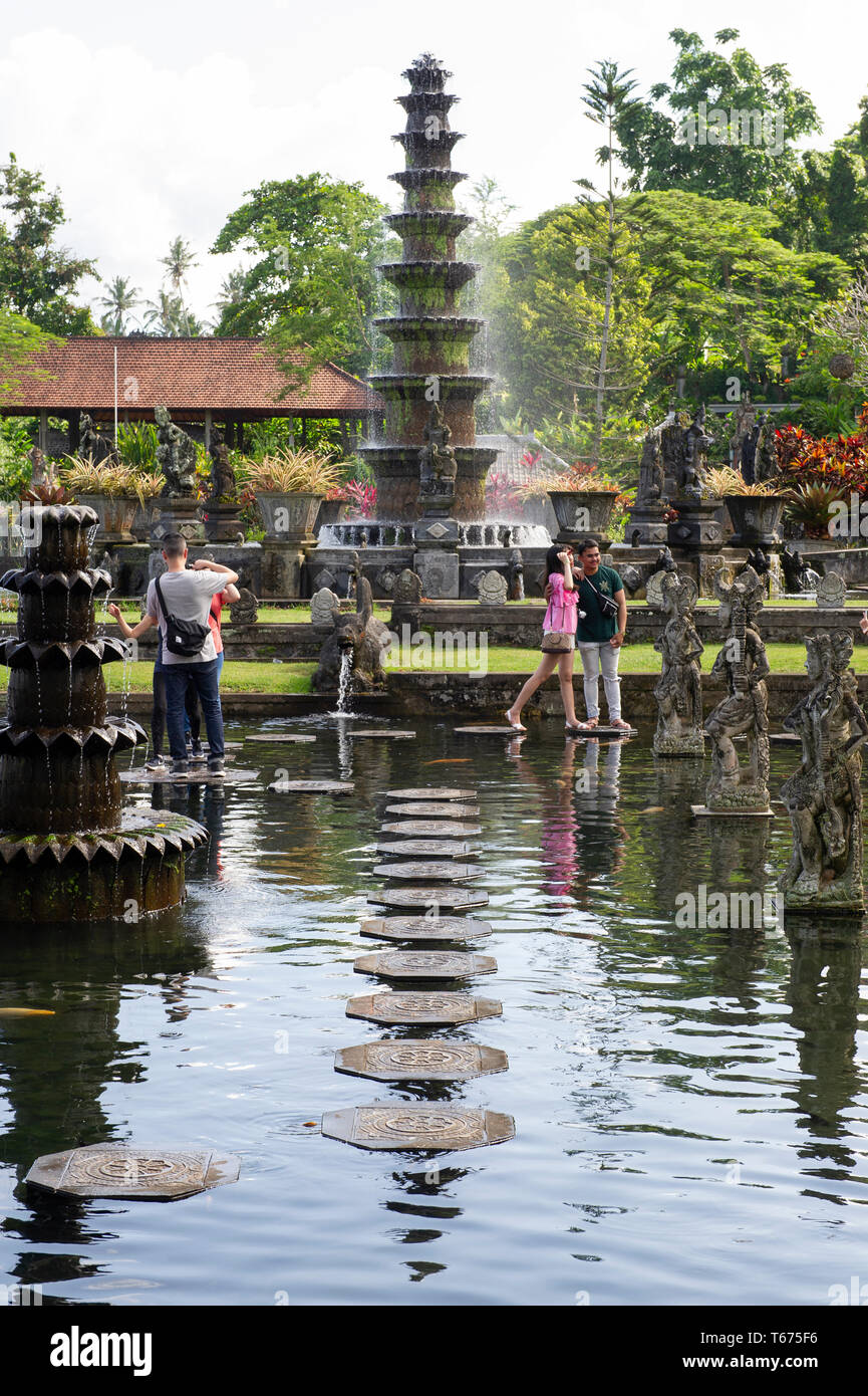 I turisti sulle pietre miliari presso la Taman Tirtagangga (l'acqua Royal Palace e Giardini) a Bali, in Indonesia Foto Stock