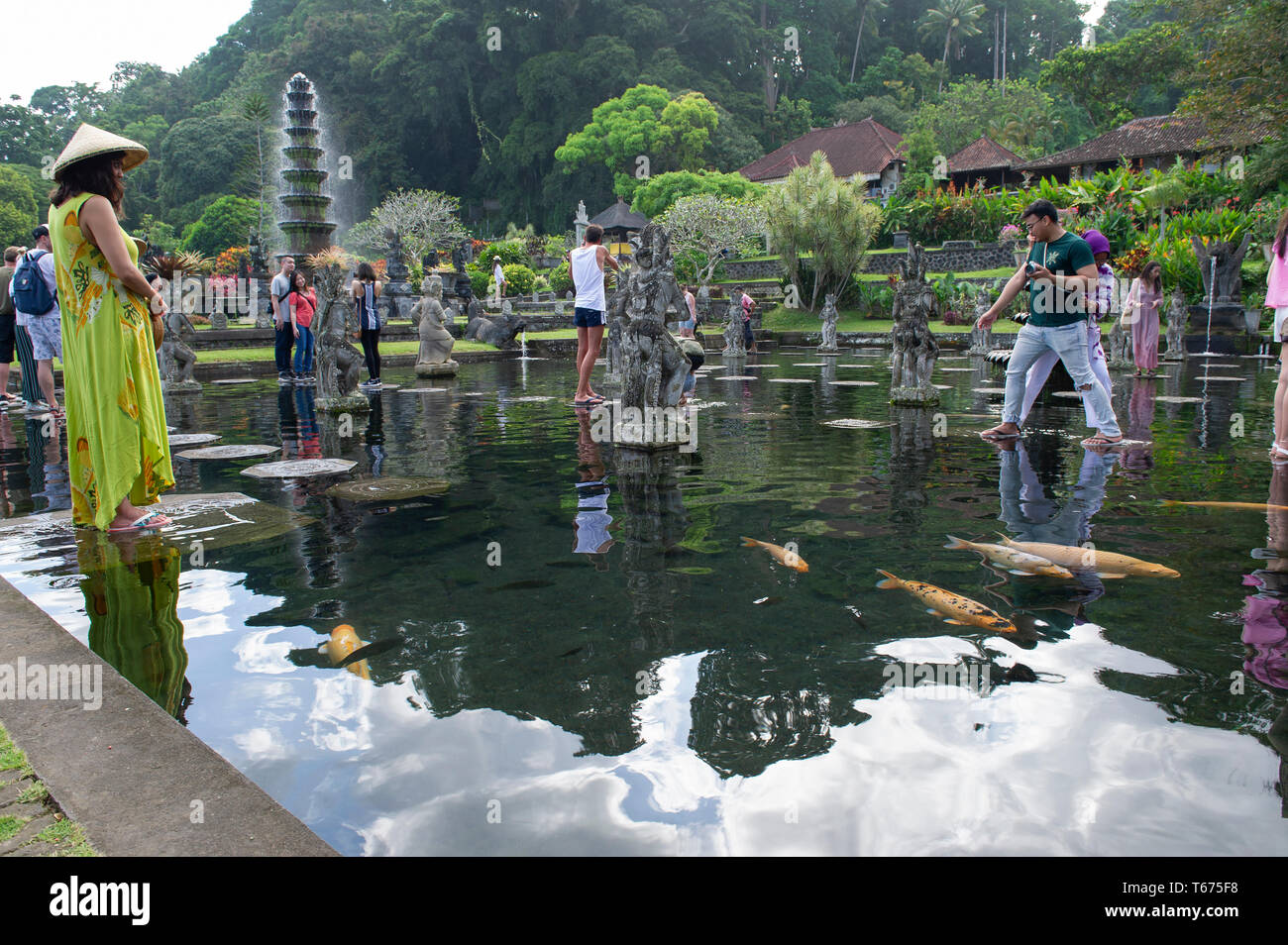 I turisti sulle pietre miliari presso la Taman Tirtagangga (l'acqua Royal Palace e Giardini) a Bali, in Indonesia Foto Stock
