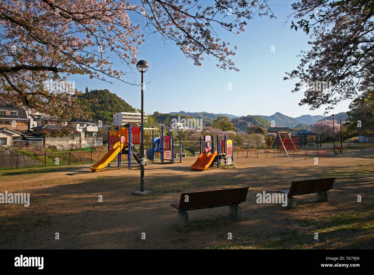 Piccolo parco e playgound con fiori di ciliegio in Giappone Foto Stock