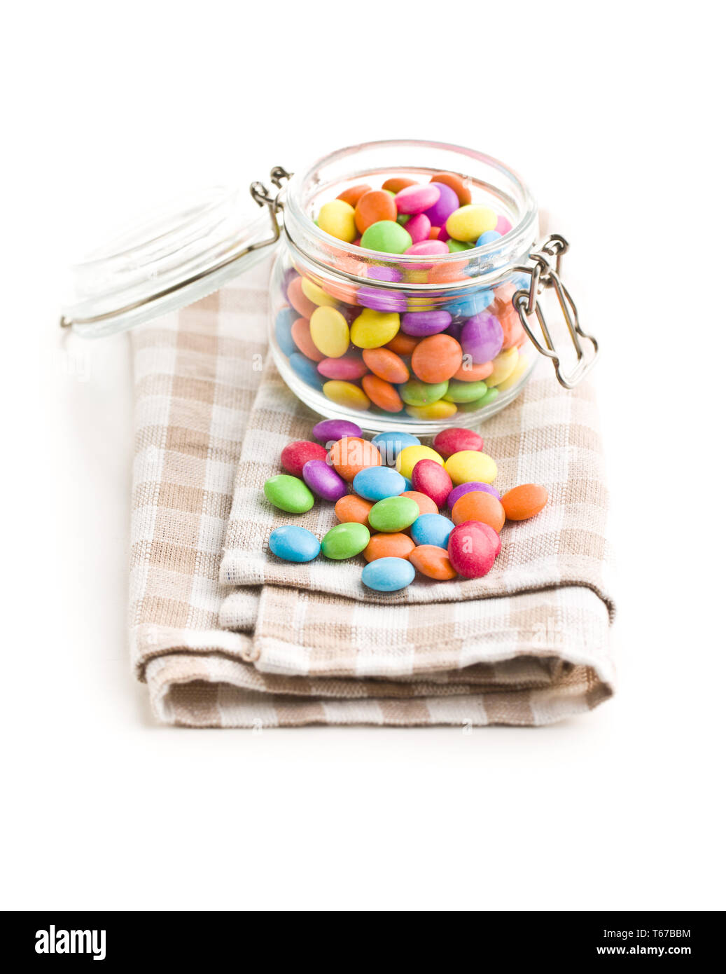 Cioccolato colorato candy pillole sul tovagliolo isolati su sfondo bianco. Foto Stock