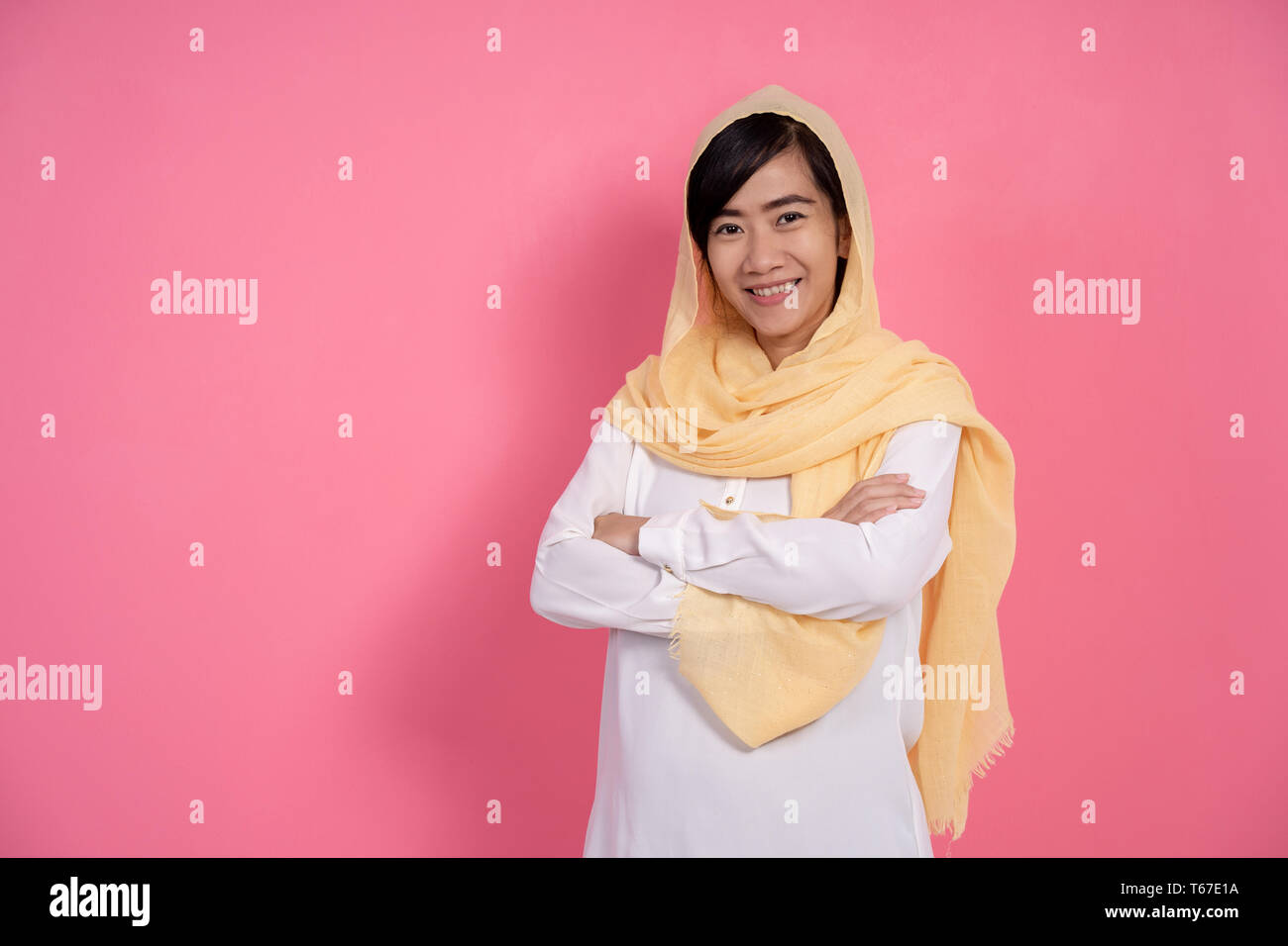 Donna musulmana del braccio incrociato sorridente Foto Stock