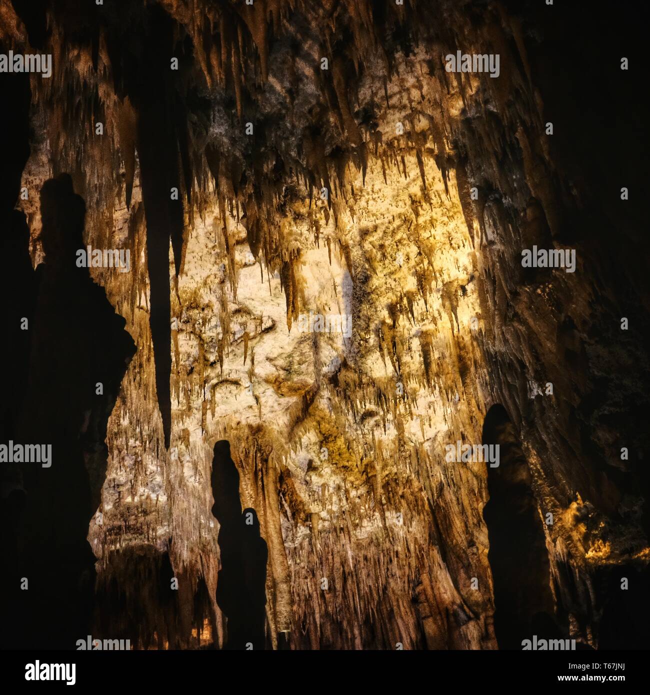 Una grotta creepy con rocce naturali affilate sul soffitto Foto Stock