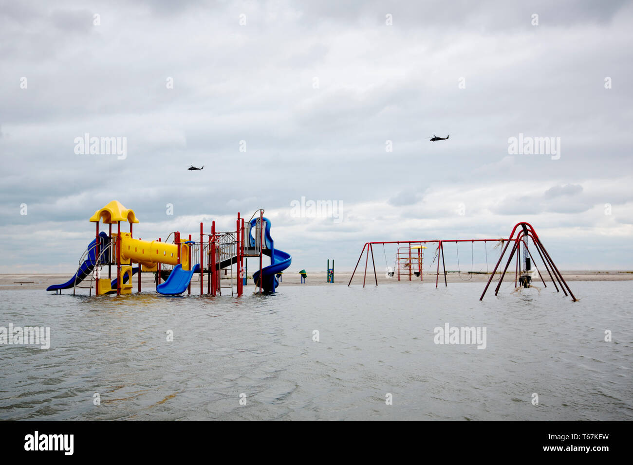 Due Black Hawk elicotteri volare oltre un invaso il parco giochi nel punto arioso quartiere di Rockaways. Tre elicotteri navi di supporto sono state inviate alla costa di New York e New Jersey per gli aiuti per il salvataggio e il recupero dopo l'superstorm Sandy. Foto Stock