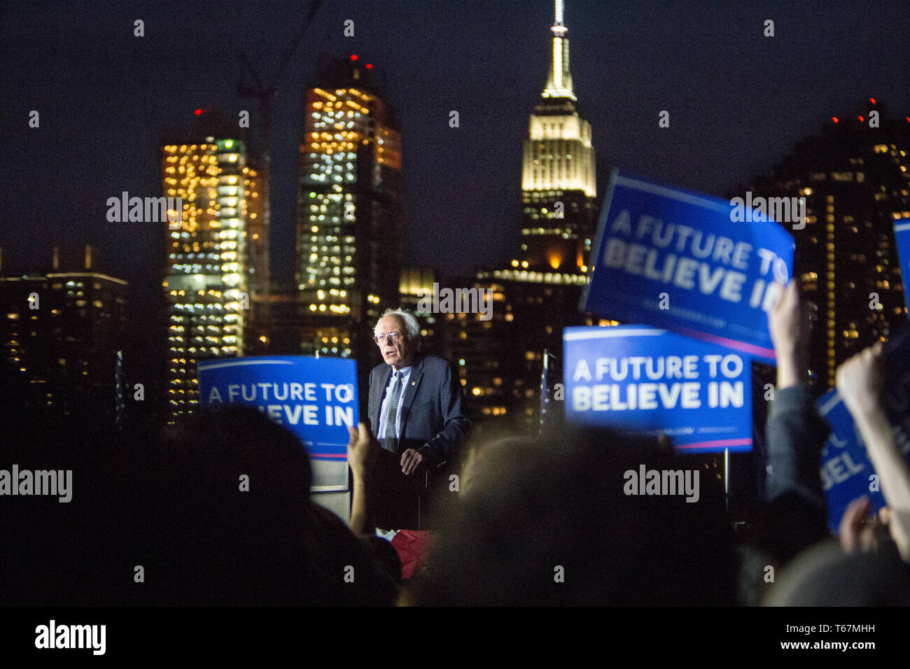 Alla vigilia delle elezioni primarie dello Stato di New York nel 2016, il senatore presidenziale Bernie Sanders (D-Vt) tiene un ultimo rally nel Hunters Point South Park di Queens. Lo slogan della sua campagna "un futuro da credere" è su tutti i poster, e con lo skyline di Manhattan come sfondo con l'Empire state Building chiaramente visibile. Foto Stock