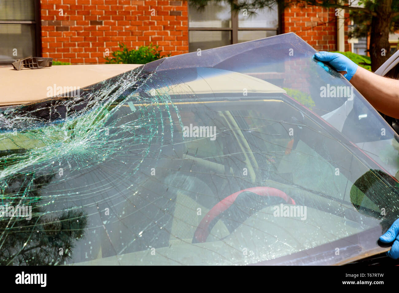 Rimuovere i lavoratori si è schiantato il parabrezza di un auto in auto servizio oudoors Foto Stock