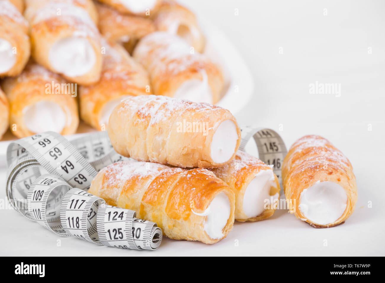 Concetto di dimagrimento, torte con nastro di misurazione Foto Stock