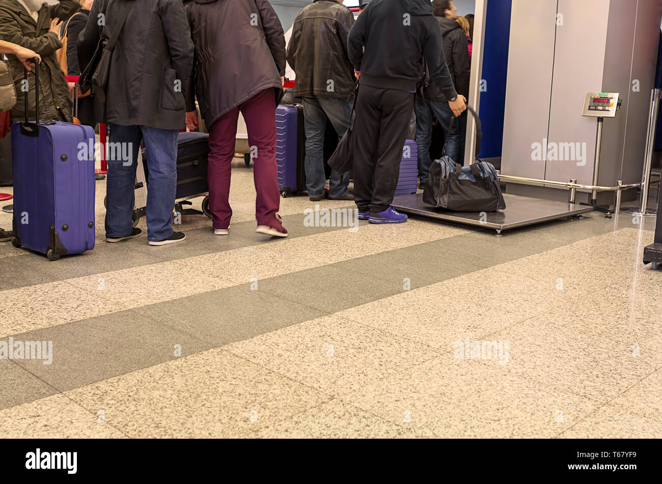 Persone in que in attesa per il check-in in aeroporto con il bagaglio, immagine Foto Stock