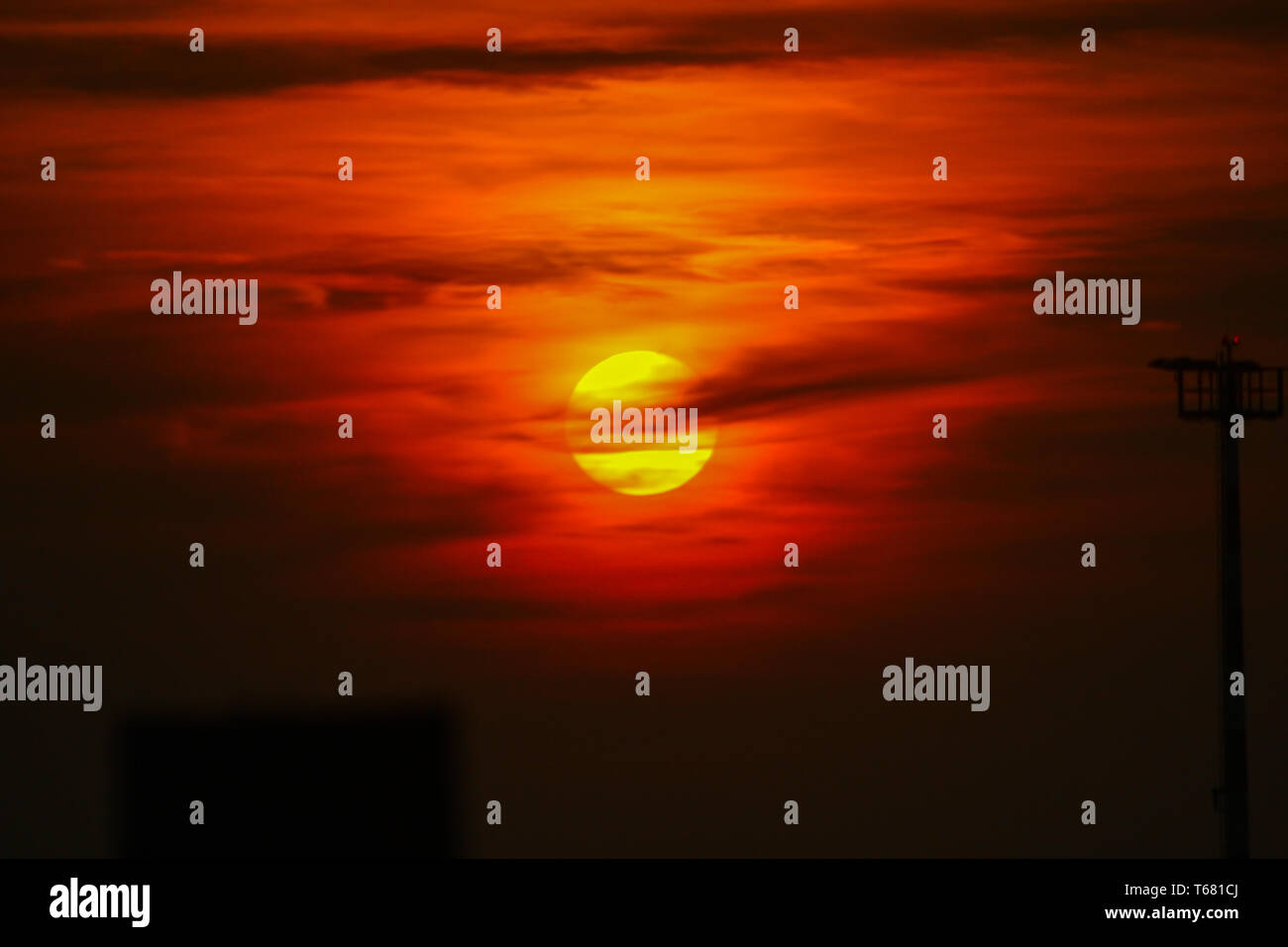 Il giallo sole con nuvole arancione Foto Stock