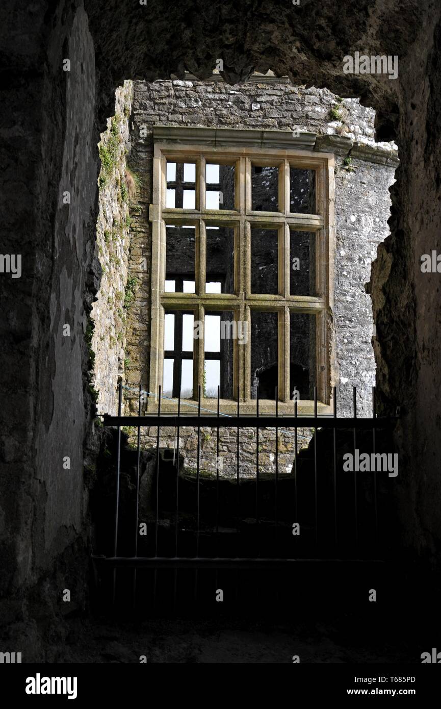 La vista di una finestra di Tudor attraverso una finestra in rovina a Carew Castle, Pembrokeshire Foto Stock