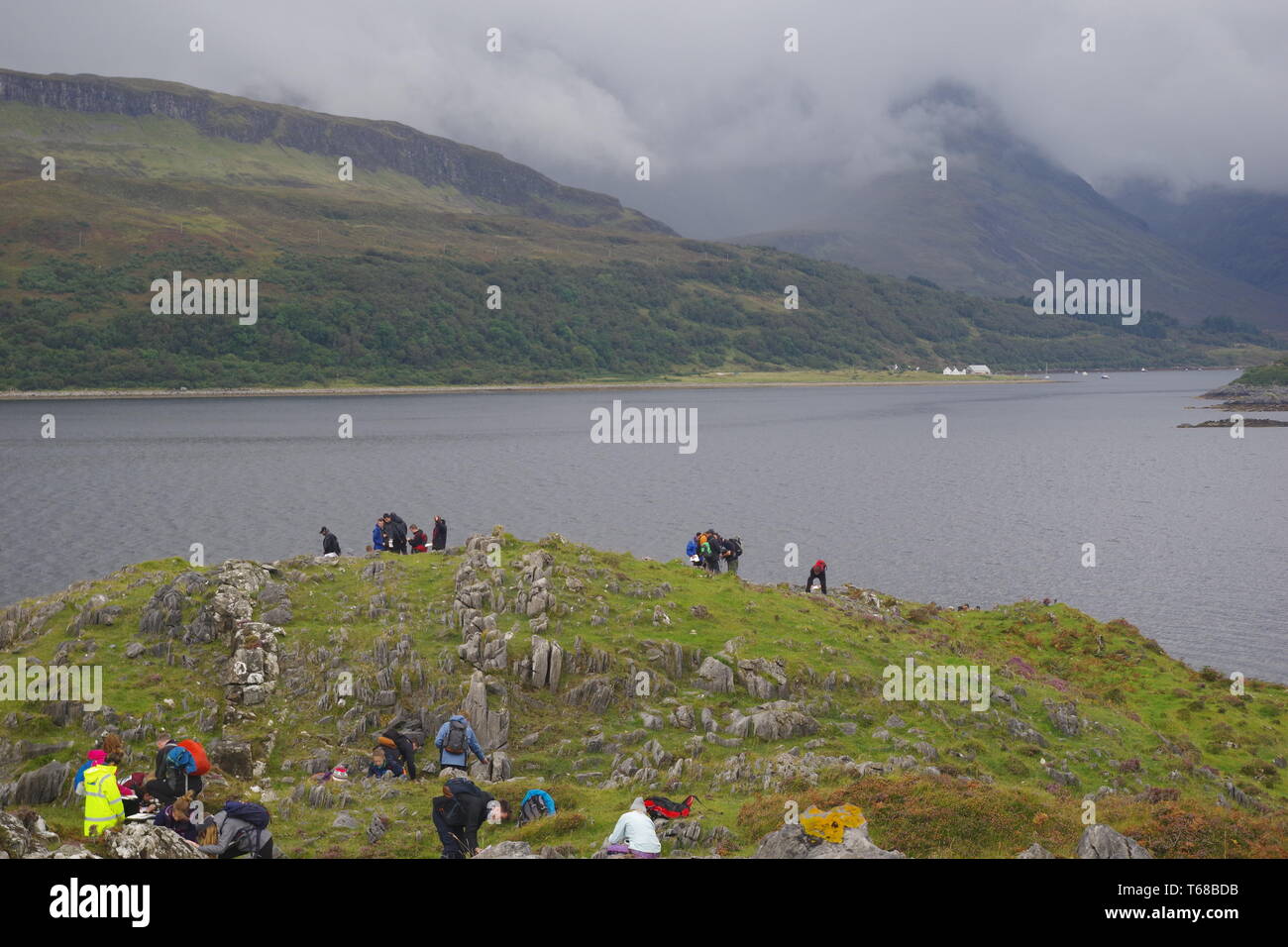 Escursionisti in Loch Slapin e Cullin Hills, Bla Bheinn su un Nuvoloso Giorno d'autunno. Isola di Skye, Scotland, Regno Unito. Foto Stock