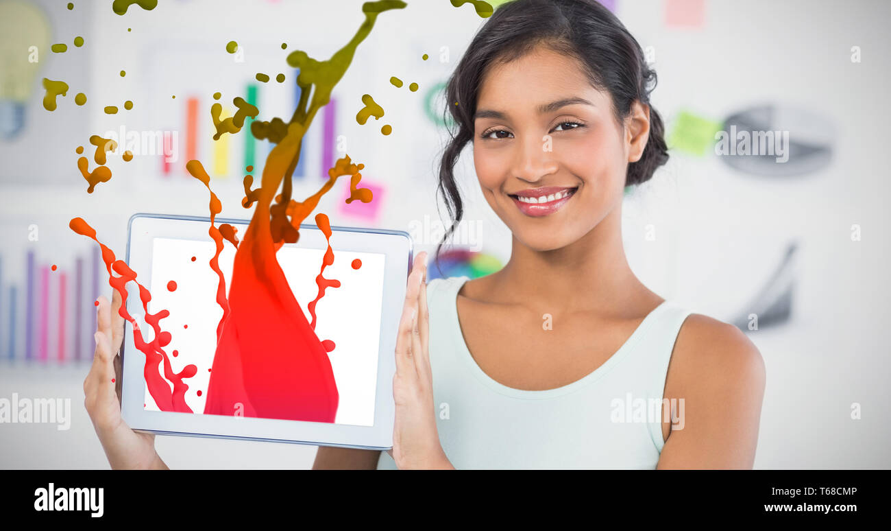 Immagine composita di felice imprenditrice che mostra digitale compressa in ufficio creativo Foto Stock