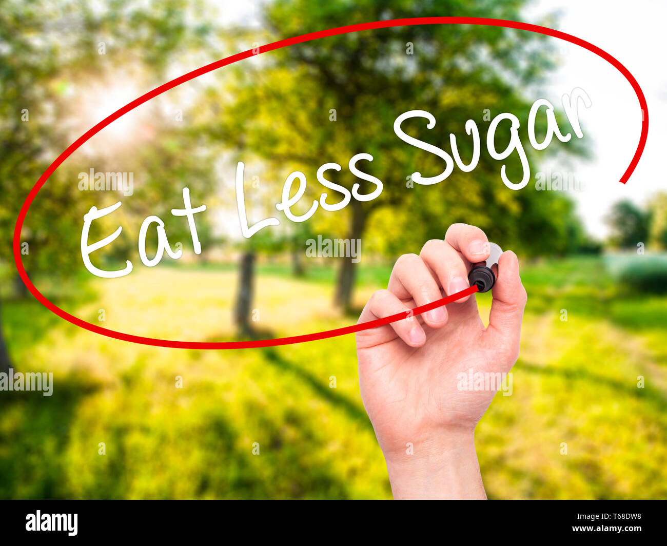 Man mano che scrive mangiare di meno di zucchero con il pennarello nero su schermo visivo Foto Stock