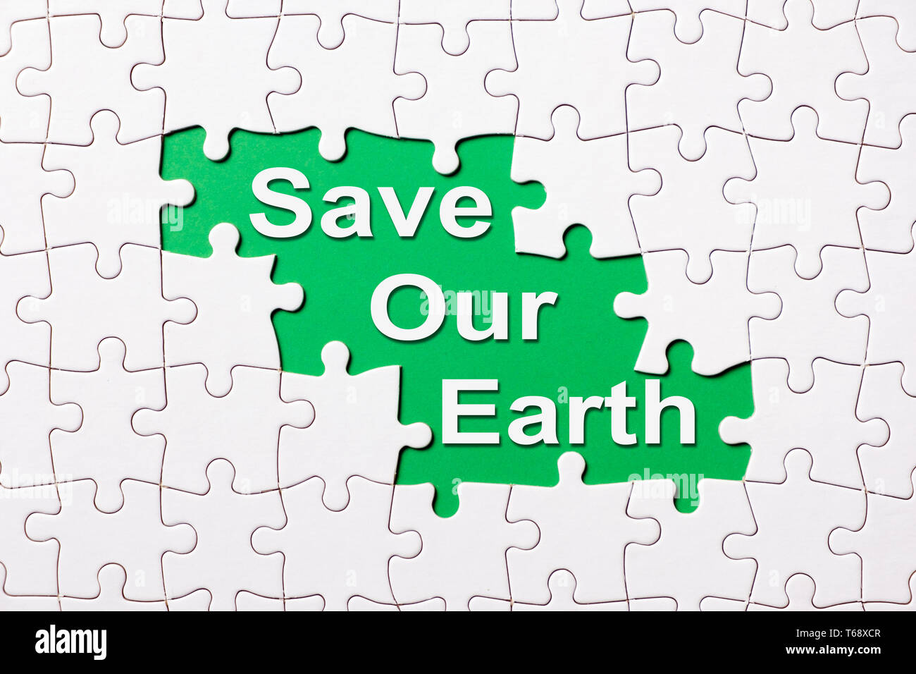 Salvare la nostra terra parola rivelano sotto puzzle Foto Stock