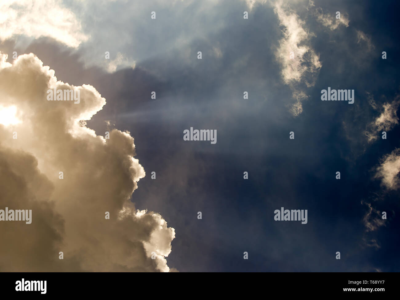 Passato il mezzogiorno i raggi solari rompere attraverso una fitta e grigio cumulus cloud su di un altopiano delle montagne andine della Colombia centrale. Foto Stock