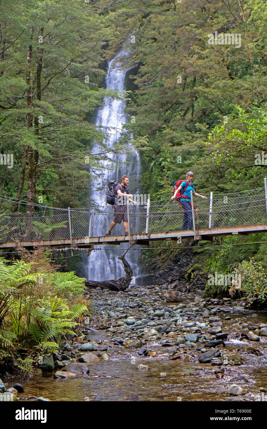 Gli escursionisti passando poco Homer cade sul Hollyford via Foto Stock