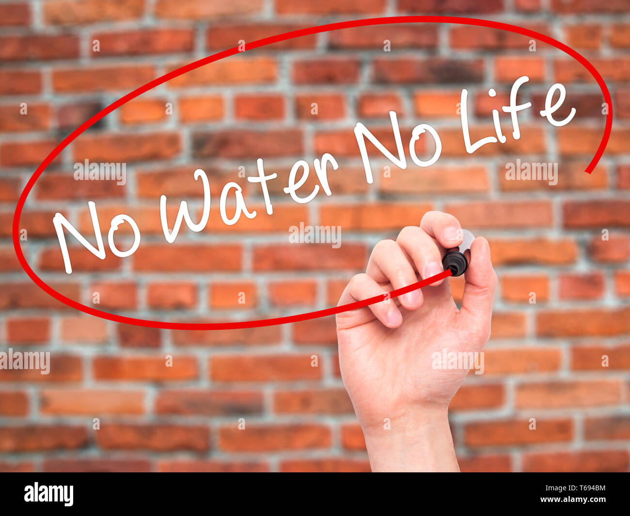 Man mano che scrive senza acqua né vita con pennarello nero su schermo visivo Foto Stock