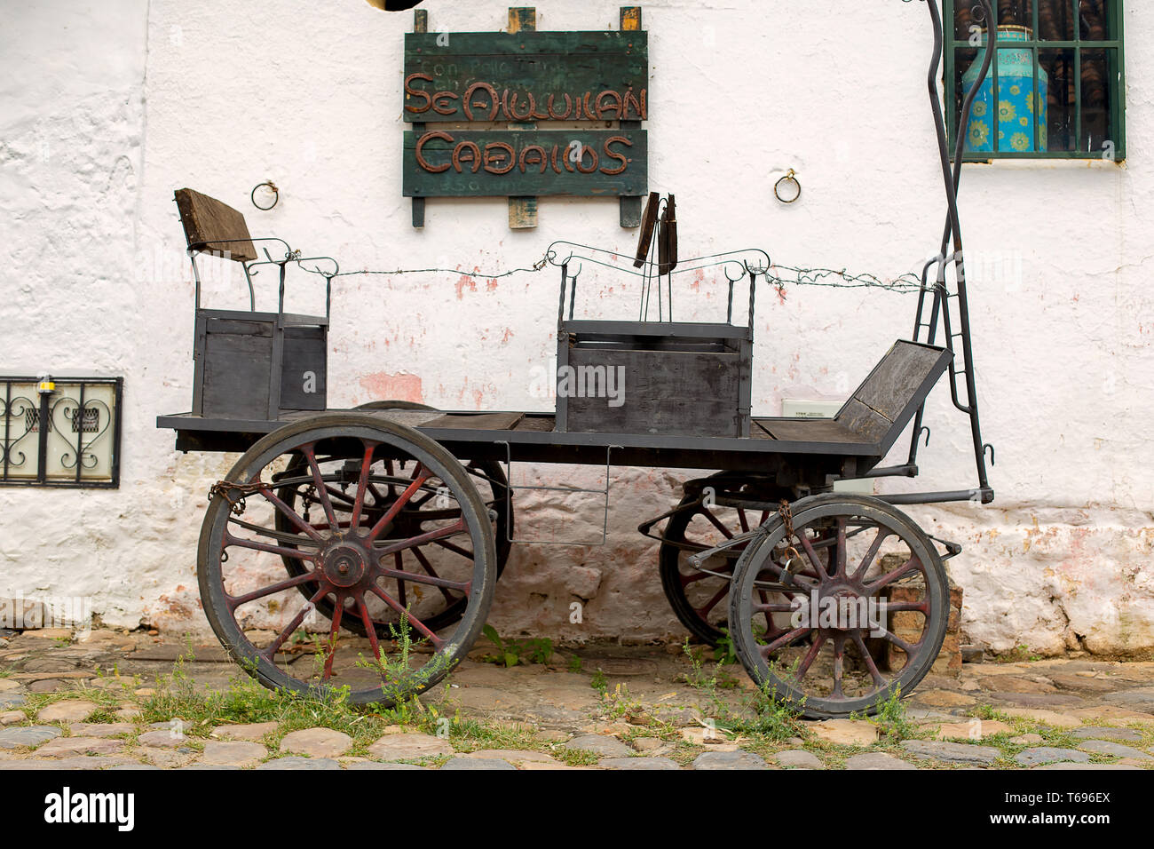 Un vecchio carrello parcheggiato a un vecchio lastricato in pietra di via di città coloniale di Villa de Leyva, nelle montagne andine della Colombia centrale. Foto Stock