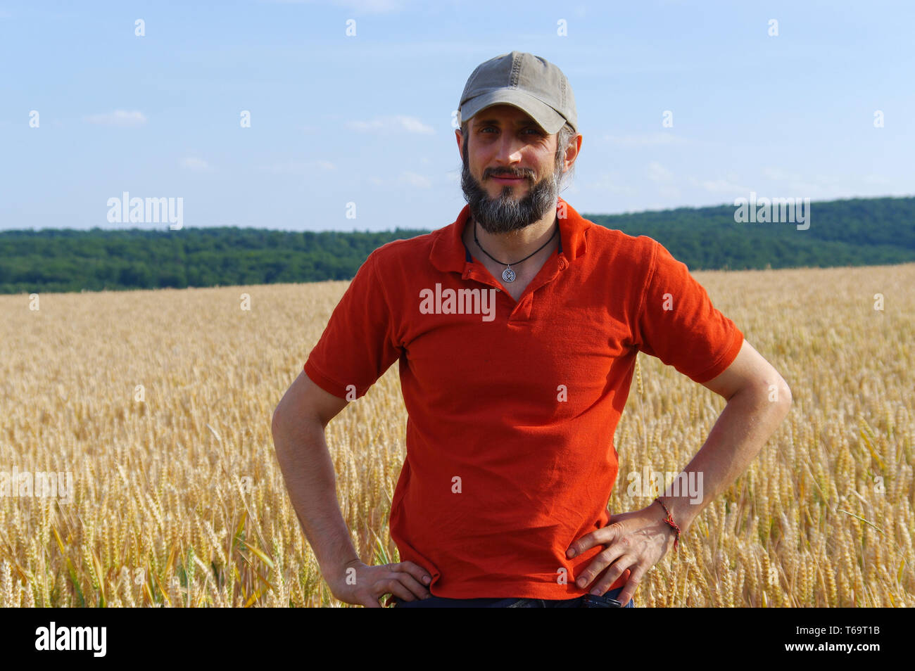 Uomo Barbuto in piedi in un campo di grano sulla giornata di sole Foto Stock