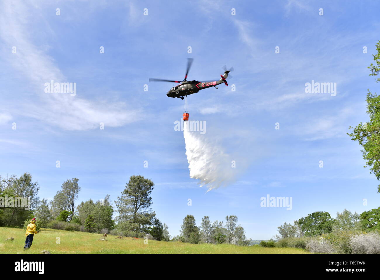 Un U.S. Esercito nazionale Guard UH-60L Black Hawk elicottero dall'esercito della California la Guardia Nazionale della task-force Medevac gocce acqua formano un secchio su un punto simulato un incendio durante una California interagenzie elicotteri militari per combattere il fuoco Programma di formazione esercizio di iun, California, 27 aprile 2019. California Esercito e Air National Guard unità elicottero treno annualmente con Cal Fire, la California Dipartimento di silvicoltura e protezione antincendio. Il partenariato migliora la California wildland antenna capacità di estinzione. (U.S. Air National Guard foto di Tech. Sgt. Julianne M. Showalter) Foto Stock