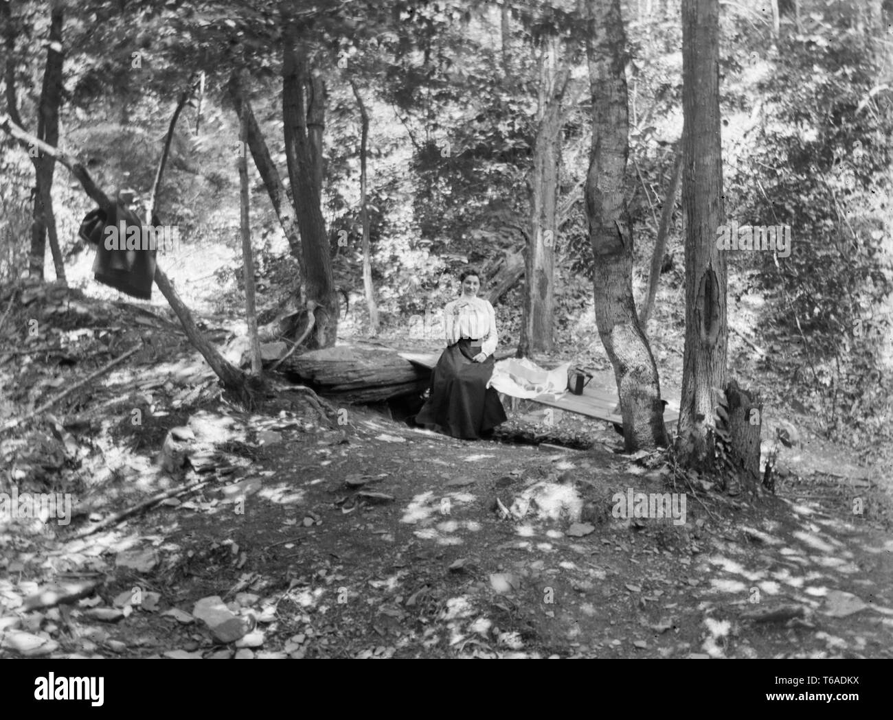 Una giovane donna vittoriana appoggia e mangia il suo pranzo, ca. 1900. Foto Stock