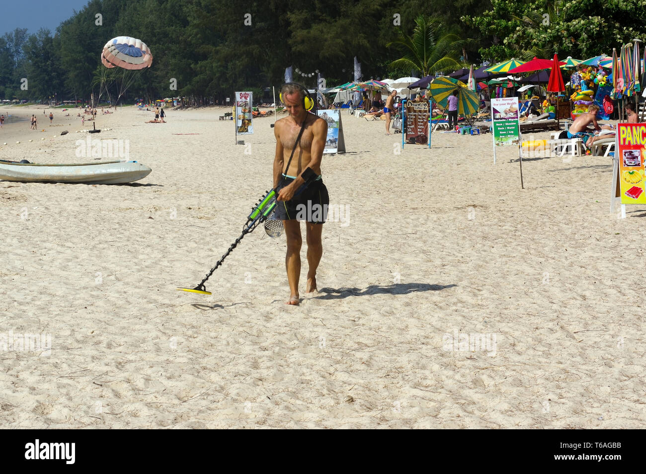 Il cacciatore di tesori con il rivelatore di metalli sulla spiaggia Foto Stock