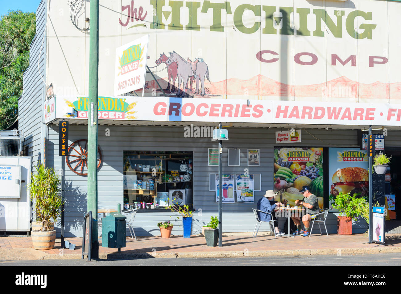 Giovane avente il pranzo sul terrazzo di una vecchia drogheria memorizza in Surat, Regione Maranoa, Queensland, QLD, Australia Foto Stock