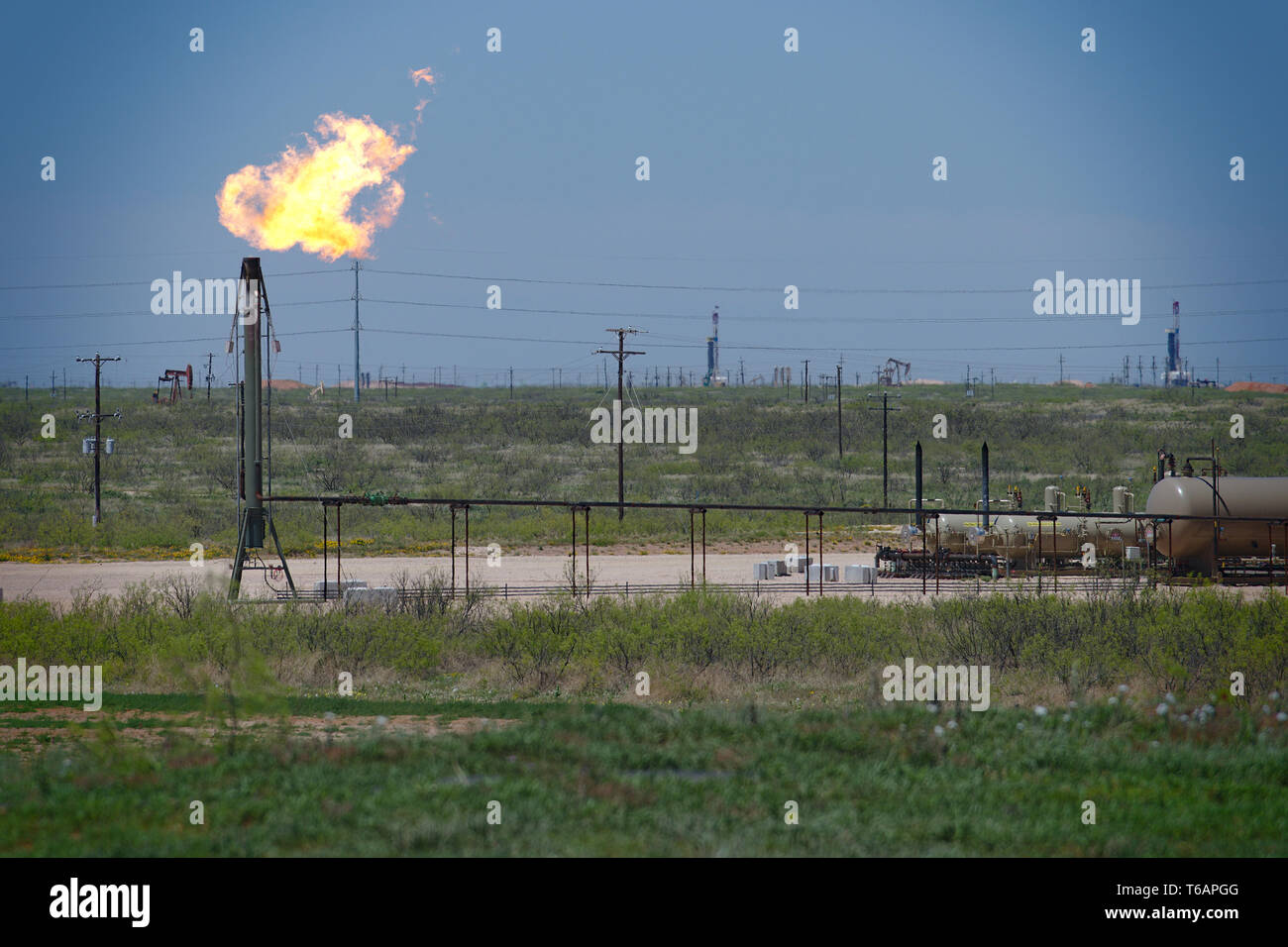 Midland, County / Stati Uniti d'America - 21 Aprile 2019: l'eccesso di gas naturale viene bruciata in un pozzo di petrolio sito. Foto Stock