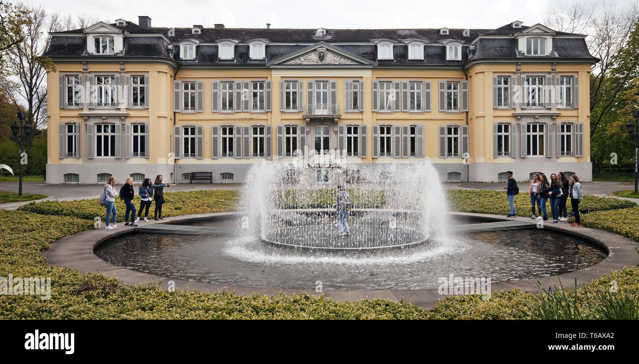 Museum Schloss Morsbroich con adolescenti presso la fontana acqua Isola, Leverkusen, Germania Foto Stock