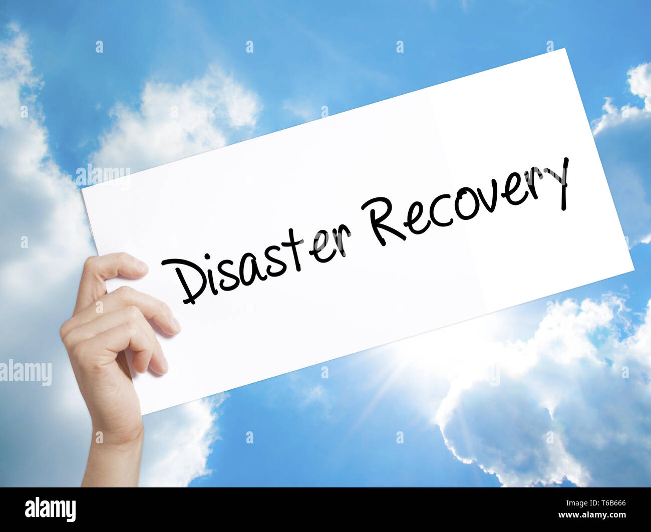 Il Disaster Recovery segno su carta bianca. Man mano che tiene la carta con testo. Isolato su sfondo cielo Foto Stock