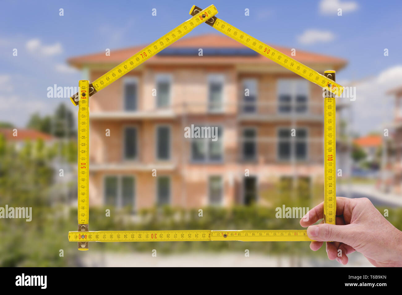 Guscio di casa in costruzione con righello in mano di agente immobiliare Foto Stock