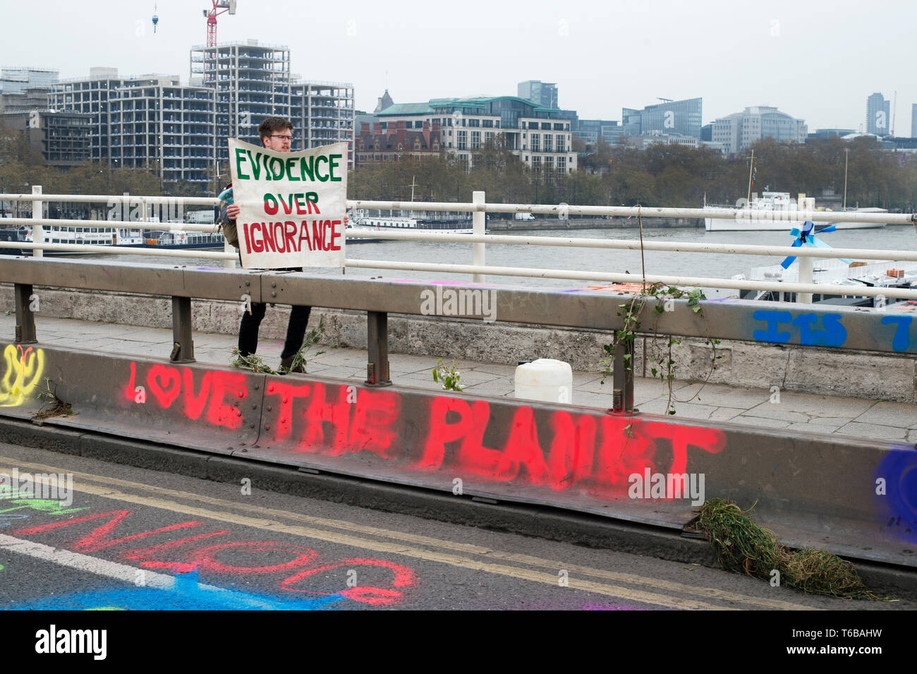 Estinzione della ribellione di protesta, London . Ponte di Waterloo. Un giovane uomo cammina portando una targhetta dicendo 'Prove oltre l'ignoranza". Foto Stock