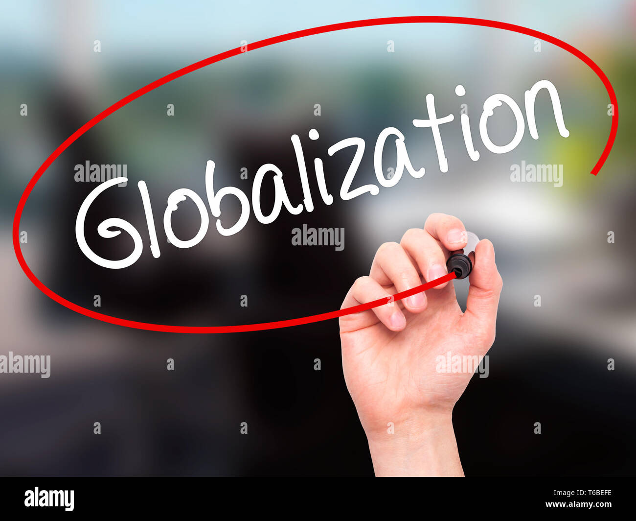 Man mano che scrive la globalizzazione con pennarello nero su schermo visivo. Foto Stock