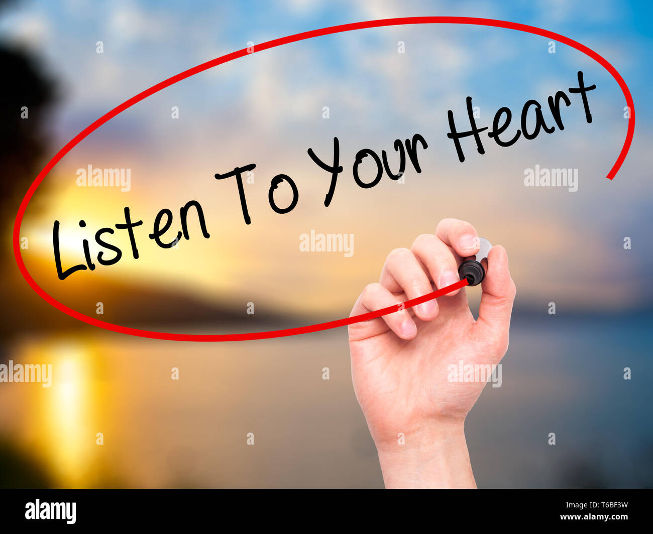 Man mano scrivere ascoltare il tuo cuore con il pennarello nero su schermo visivo Foto Stock